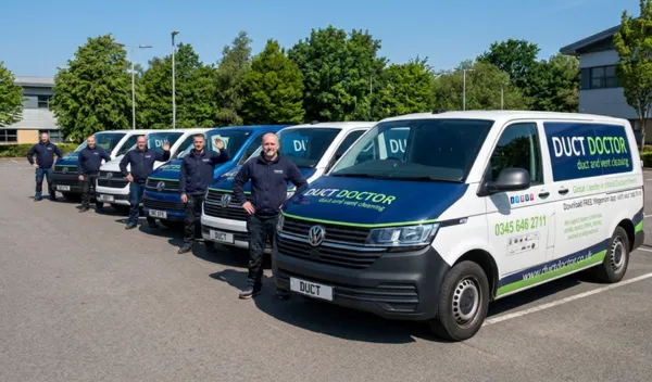 The Duct Doctor team standing beside their branded vans